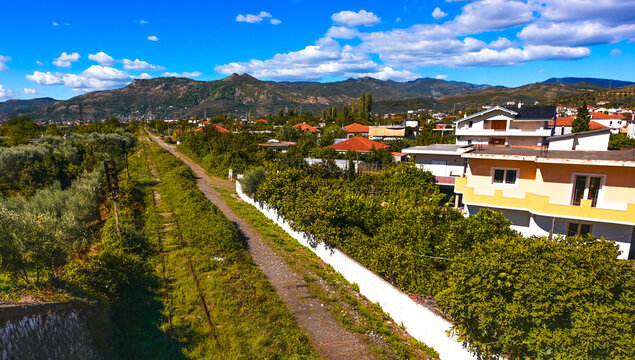 Sunny residential villa with red roof in the suburban landscape of Elbasan, Albania.