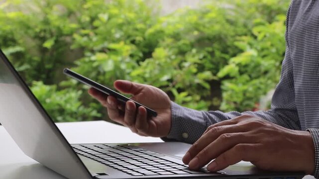 Cyber security 2FA login concept. Businessman working on laptop logging in on smartphone and modern device. Concept of remote work, freelancing, training, banking, online shopping. Cybersecurity.