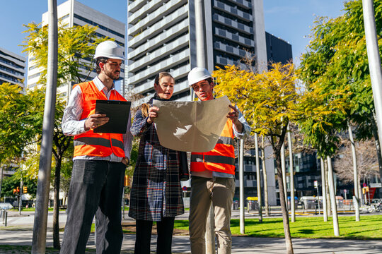 Construction team reviews site plan in modern city