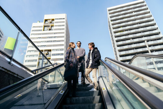 Business coworkers on escalator in modern city district