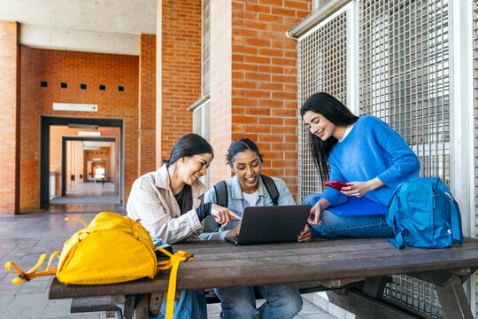 University students studying together on campus with laptop