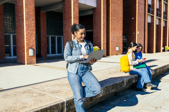 University student using laptop outdoors on campus