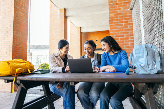 University students studying together on campus with laptop