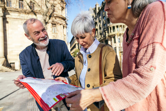Seniors exploring city with a map on a sunny day