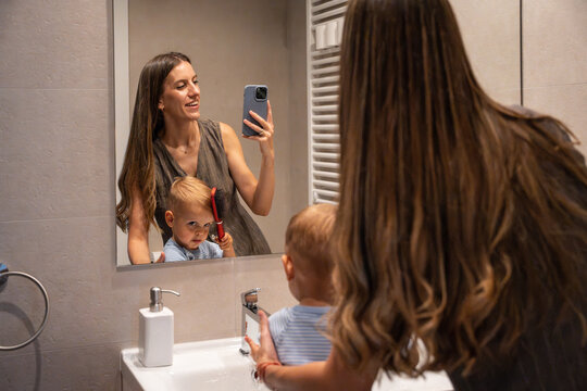 Mother takes bathroom selfie as son brushes his hair