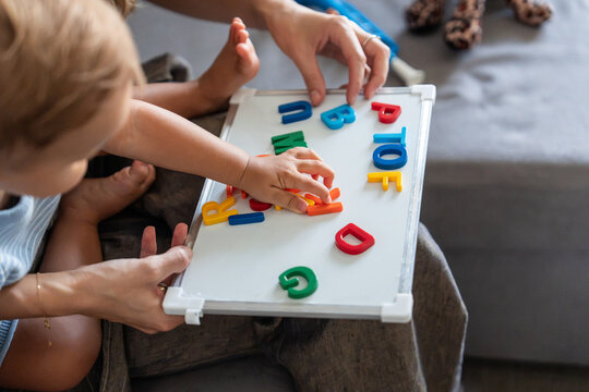 Mother and son learning alphabet with magnetic letters