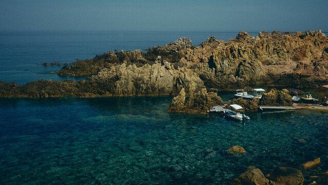 boats docked in the clear waters of Sardinia
