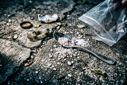 Illegal crystal methamphetamine scattered on ground with paraphernalia