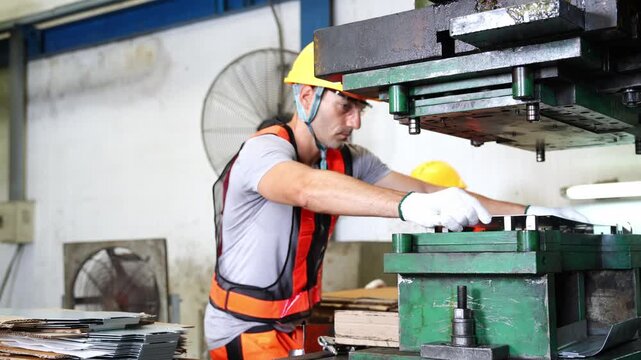 Experienced professionals using heavy equipment in an industrial workshop while wearing appropriate safety gear