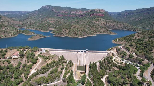 Forward reveal aerial shot of Siurana dam and Reservoir on sunny summer day. Tarragona, Spain.