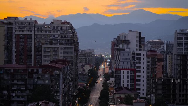 View of Chavchavadze street of Batumi with typical residential buildings, road with moving cars at sunrise - early morning. Urban and cityscape concept