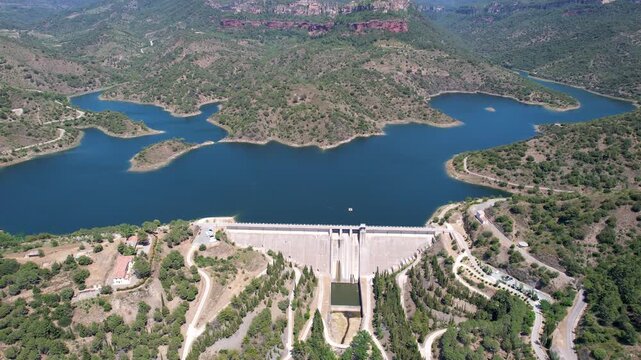 Forward reveal aerial footage of Siurana dam and Reservoir on sunny summer day. Tarragona Province, Spain.