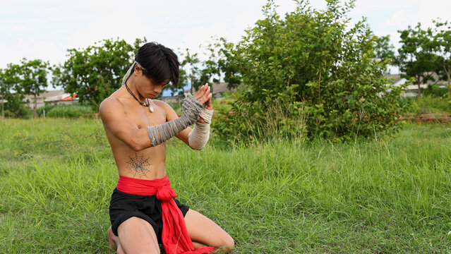 Thai Martial Artist Kneeling in Prayer During Traditional Wai Kru Ritual
