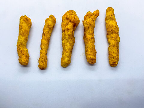 Spicy Indian Kurkure Corn Puff Snacks namkeen sticks arranged neatly in a row on a clean white backdrop. Perfect for food branding, commercial packaging, snack advertising, and junk food concepts.