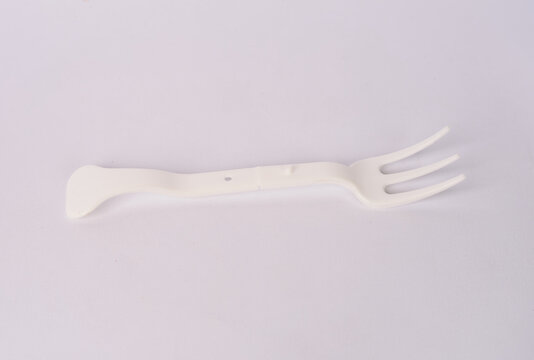 White disposable plastic fork with three tines isolated on white background

