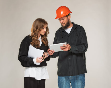 businesswoman architect and worker with beard in hard hat with tablet isolated