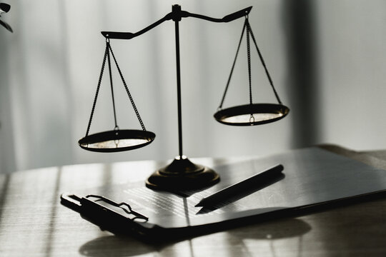 Silhouetted scales rest on a polished surface. Pen and clipboard lie beside them, ready for use. Soft light casts gentle shadows across the scene. The image evokes calm, thoughtful deliberation