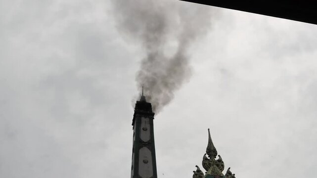 Black smoke rising from the crematorium chimney during a cremation indicates the combustion process occurring in the furnace below.