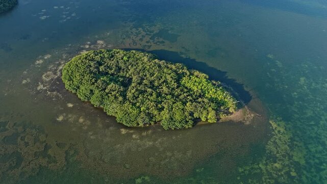 Island in sea. Green island surrounded by sea. Aerial landscape view on island in ocean. Travel and tourism. Traveling and adventure