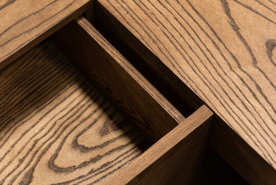 Close-up of open wooden drawer with detailed grain craftsmanship.