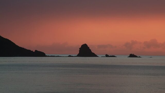 奄美大島の夏の夕日 黄金色に染まる海とリーフの海岸風景