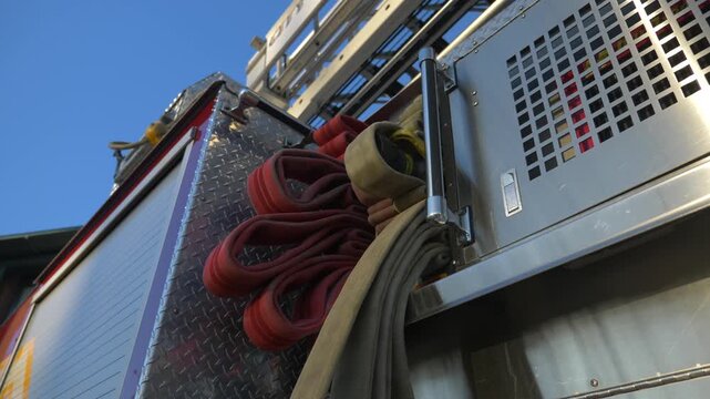 Close up of firefighting equipment and hoses on fire truck in evening sunlight cinematic video footage.