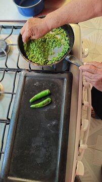 Woman Hand Stirring Guaje Seeds in Skillet for Roasting