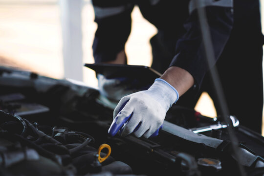 Close Up of Professional Mechanic Using Precision Hand Tools for Vehicle Engine Maintenance in Modern Automotive Repair Workshop and Service Center