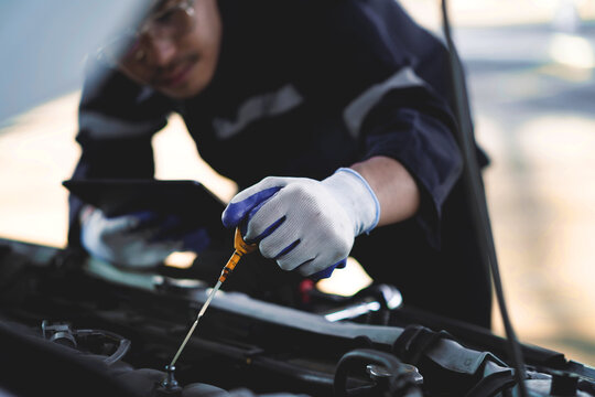 Close Up of Professional Mechanic Using Precision Hand Tools for Vehicle Engine Maintenance in Modern Automotive Repair Workshop and Service Center