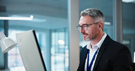 Fototapeta premium Business, man and smile with computer in office for risk assessment, finance news or insight. Review, mature financial advisor and tech at agency for market tracking, ai scenario planning and reading