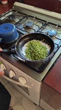 Pouring Fresh Green Guaje Seeds into Cooking Frying Pan