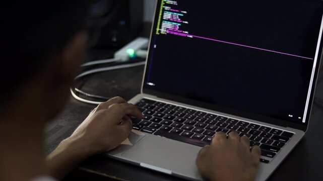 Software Developer Writing Code on Laptop in Modern Workspace