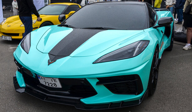 Mint green Chevrolet Corvette C8 with dual black racing stripes, revolutionary mid engine supercar represents milestone transition for the iconic American muscle heritage