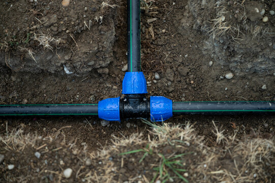 Installation of polyethylene irrigation pipes with compression tee fitting in trench
