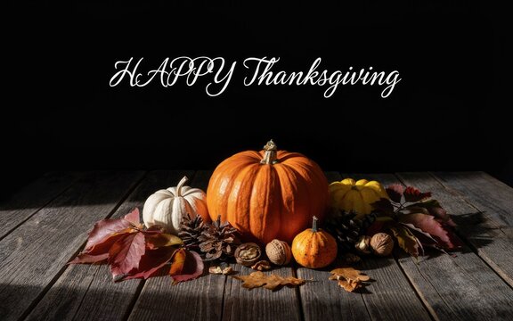 Rustic autumn pumpkin arrangement with decorative leaves on a wooden table for thanksgiving day holiday celebration