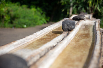 Fototapeta premium Traditional salt pan with black stones in Bali