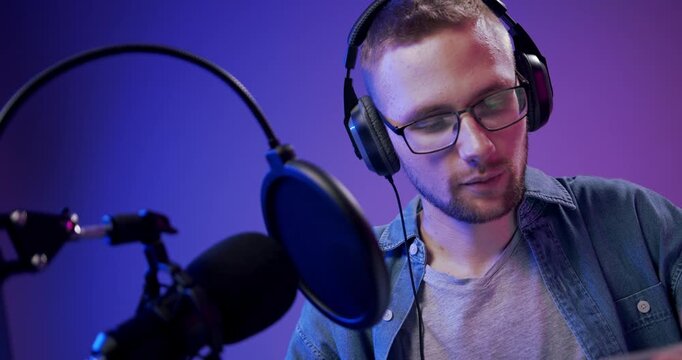 Podcast host speaking into a professional microphone while recording online content.