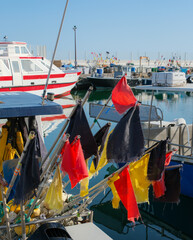 Colorful fishing marker flags and gear on a small fishing boat in the harbor of Saintes-Maries-de-la-Mer, Camargue, France. Small-scale fisheries and traditional Mediterranean fishing. © Ganna Zelinska