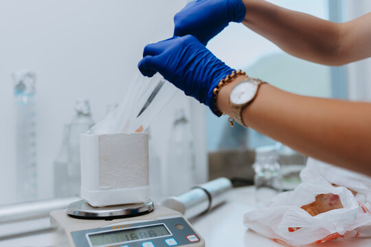 Laboratory Technician Weighing Material On Precision Scale While Preparing Sample With Gloves