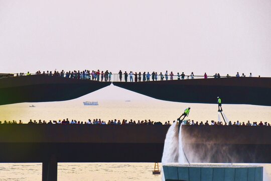 Phu quoc, Vietnam - 15th february, 2024: Crowd of spectators tourist on Kiss bridge during water show on Sunset town in Phu Quoc, Vietnam. Hoverboard show performance in public