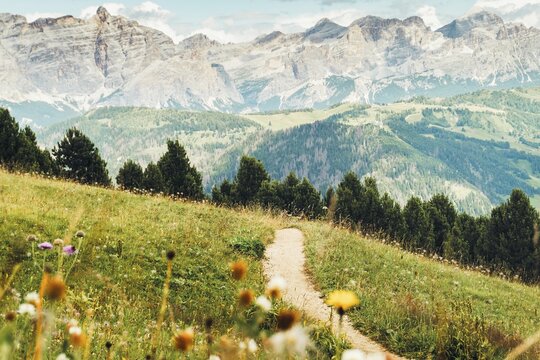 Aerial view Beautiful Dolomites mountain landscape Italy rocky jagged peaks green alpine valley meadows pine trees clouds blue sky scenic summer wilderness nature travel vista