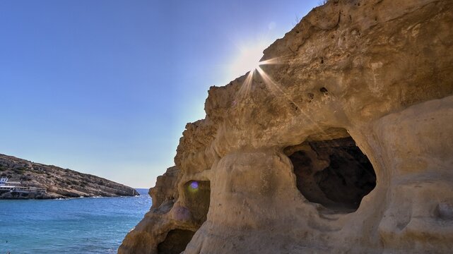 Neolithic caves, former hippie paradise, cave with sunbeams over the sea, natural rock formations, clear sky, Matala, south coast, Crete, Greek islands, Greece