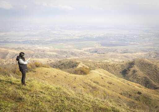 Female person takes a photo from black mountain viewpoint in Vashlovani.Georgia
