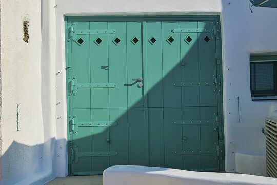Close-up of green door in white building with shadow effect, Syrmata, boat garages, boathouse, boathouses, beach house, Goupa, Goypa, Goupa Kara, Kimolos, Cyclades, Greek Islands, Greece