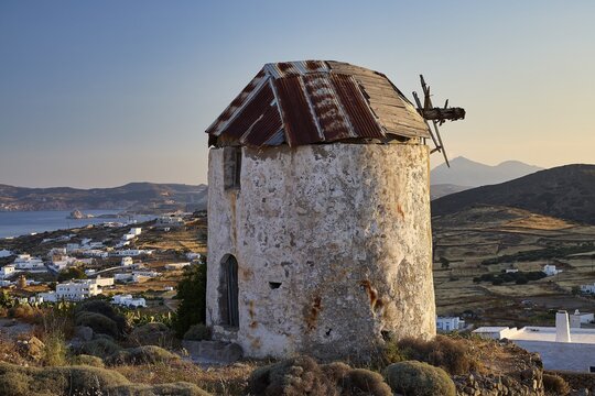 Windmill above Chorio on Mount Xaplovouni, abandoned mill on a hill with sea view at sunset, main town on Kimolos, Kimolos, Chorio, Kimolos island, neighboring island of Milos, Cyclades, Greek Islands, Greece