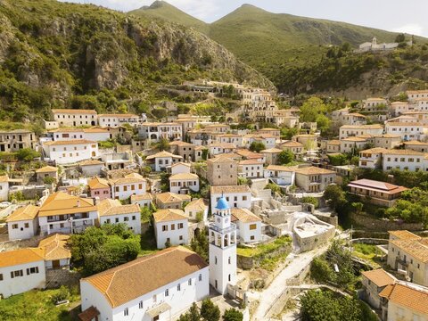 Stunning aerial panorama historic Saint Mary Monastery or Kisha e Shen Merise perched atop the old village of Dhermi, overlooking traditional Dhermi stone houses