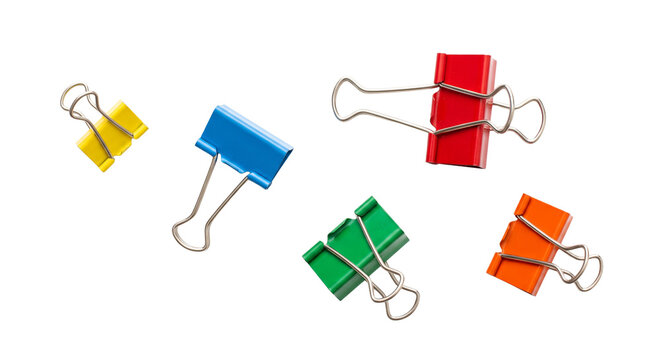 Assortment of colorful binder clips scattered against a clean white background
