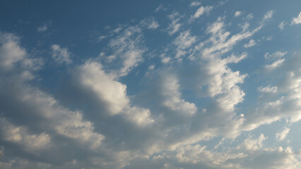 Obraz premium Low angle shot of soft white cumulus clouds floating in a clear blue sky on a bright sunny day, perfect for sky replacement, nature backgrounds, weather, and environmental design.