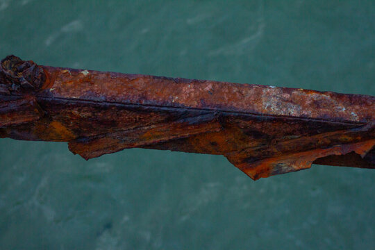 Rusted Iron Metal Beam Over Sea Water Surface Close Up