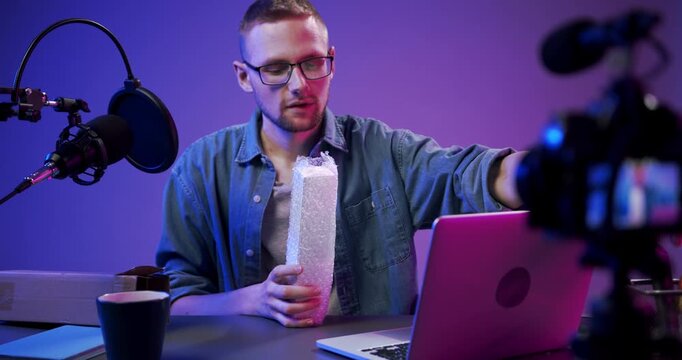 Content creator unboxing a product while recording a review in a professional studio.